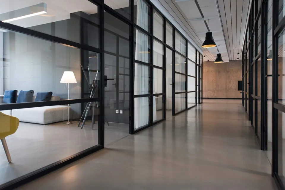 An empty office hallway with meeting rooms.