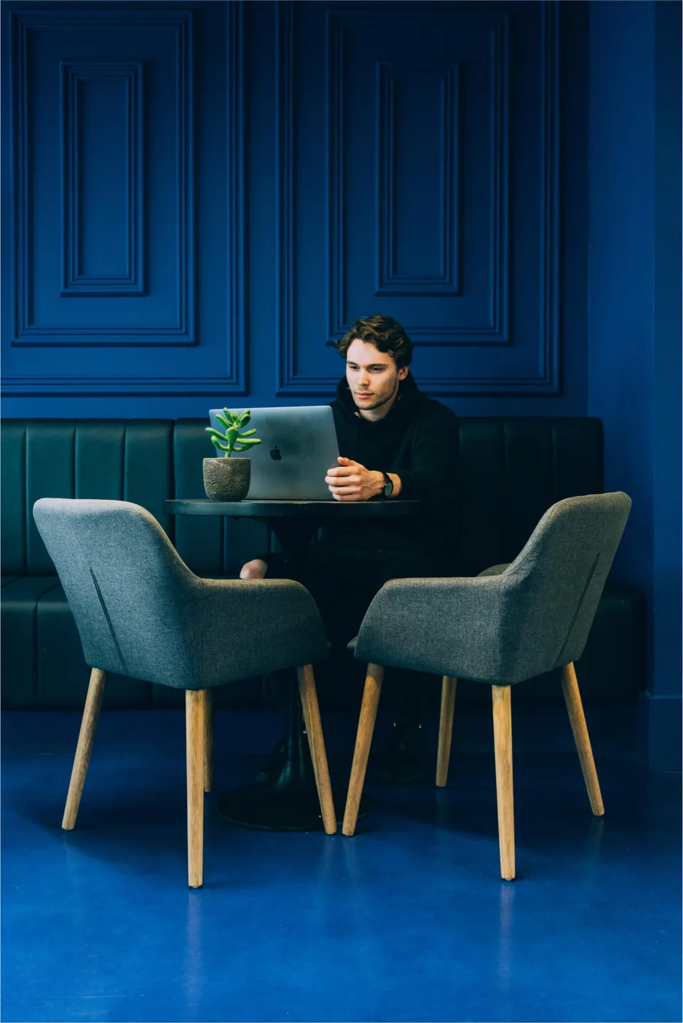 A man sitting on a table with a laptop.